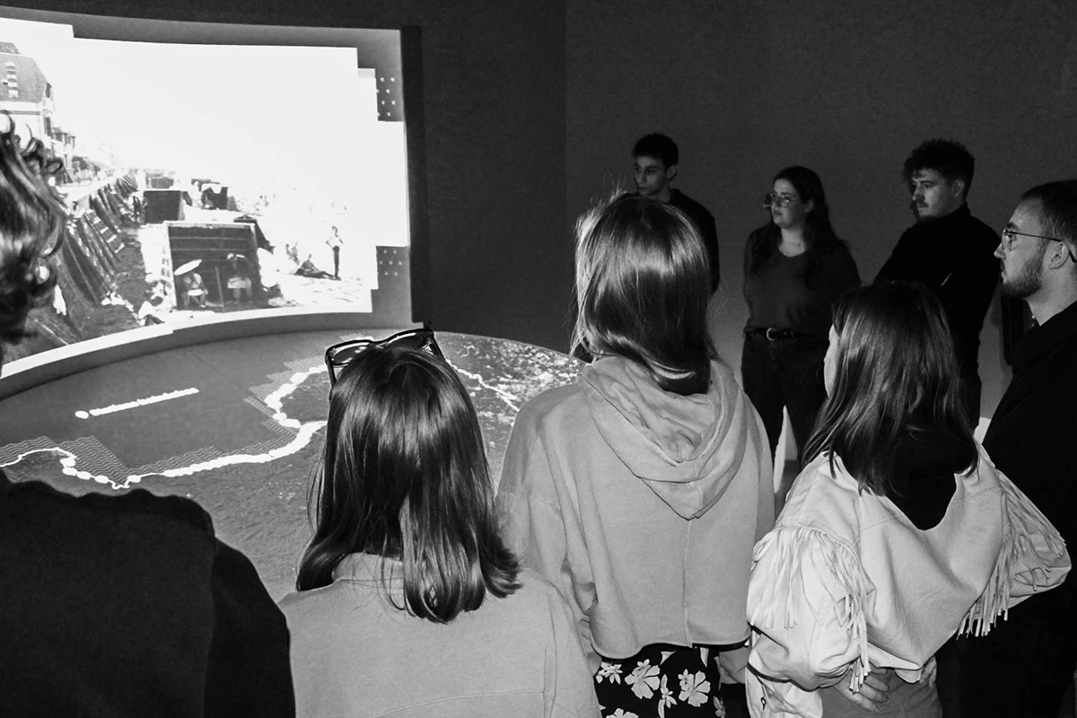 Atelier avec des enfants de primaire. Trois fillettes font une activité manuelle, accompagnée d'un médiateur.